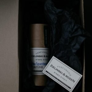 Top view of perfume packaging with elegant design in a carton box and dark aesthetic.