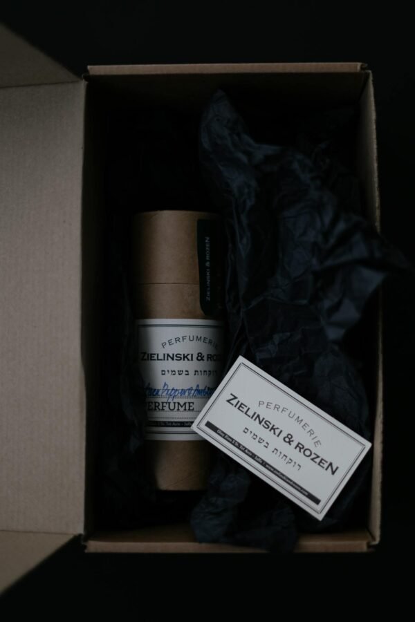 Top view of perfume packaging with elegant design in a carton box and dark aesthetic.
