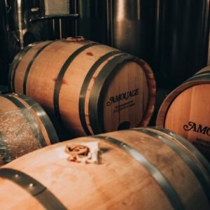 Wooden barrels in a Muscat factory, reflecting classic luxury and craftsmanship.