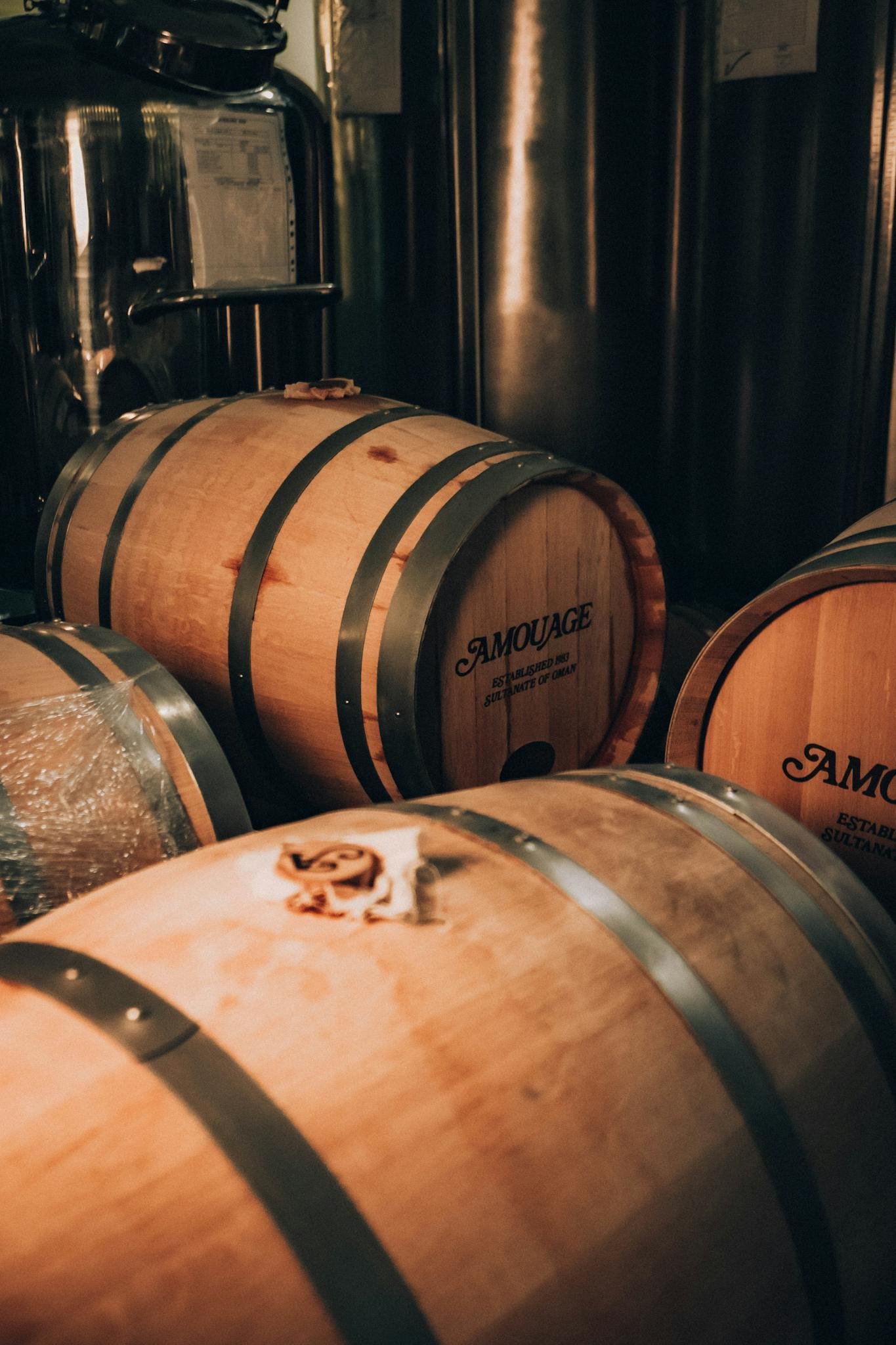 Wooden barrels in a Muscat factory, reflecting classic luxury and craftsmanship.